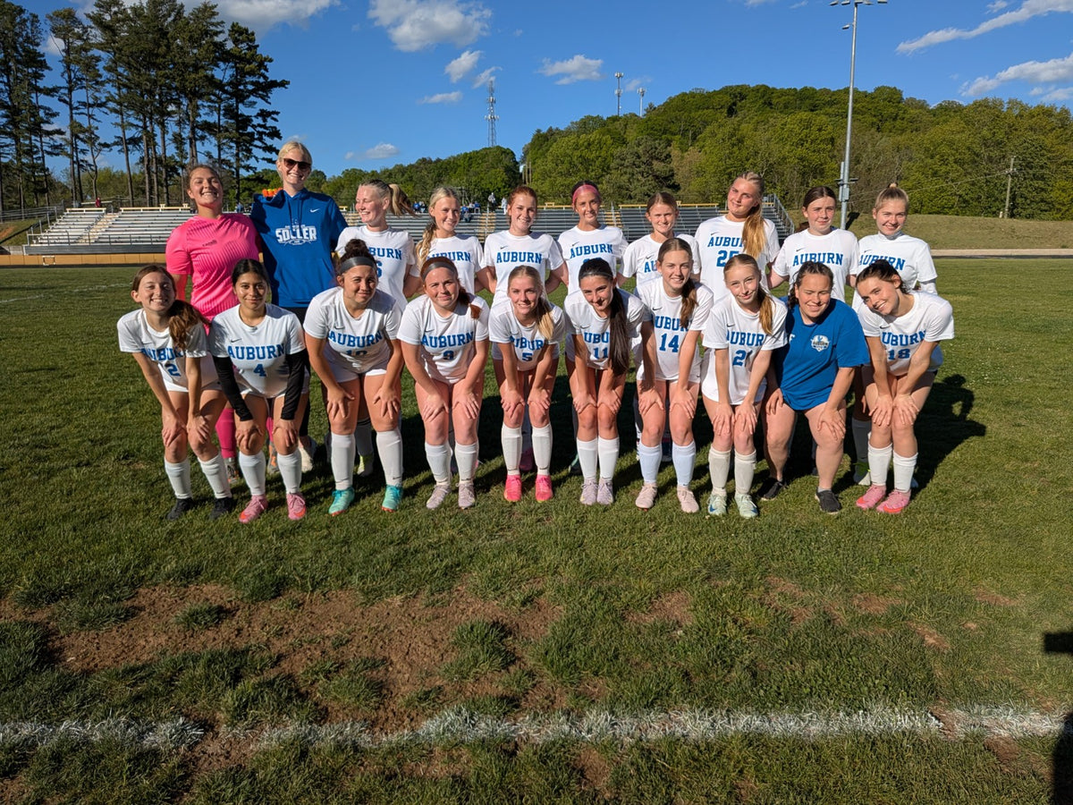 Auburn soccer team posing together on the field