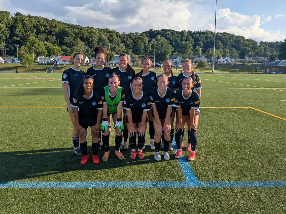 Women's soccer team posing together on the field