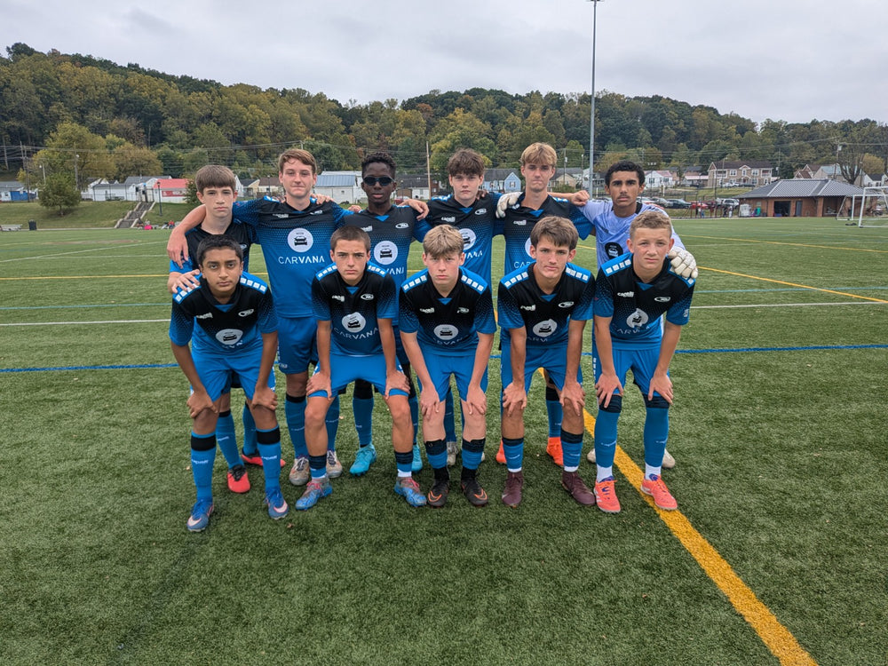 Soccer team in blue uniforms posing on the field